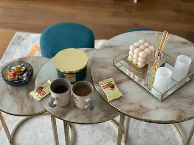 two glass tables with coffee cups and a tray of food at Apartman 5 Vrnjačka Banja in Vrnjačka Banja