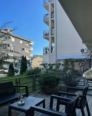 a patio with tables and chairs and a building at Apartman 5 Vrnjačka Banja in Vrnjačka Banja