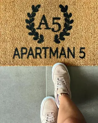 a person wearing white shoes on a rug with the words as explanations at Apartman 5 Vrnjačka Banja in Vrnjačka Banja