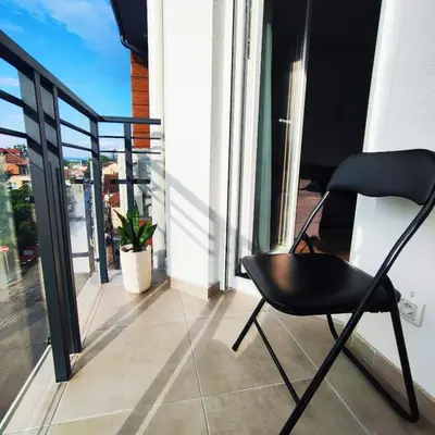 a black chair sitting on a balcony with a window at VIP Apartment in Jagodina