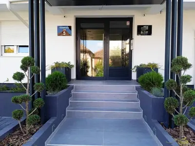 a front door of a house with stairs and plants at VIP Apartment in Jagodina