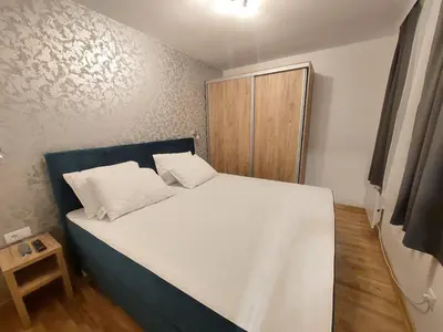 a bedroom with a large bed with a wooden cabinet at KATARINA - Lux two bedroom apartment in ski resort Kopaonik in Kopaonik