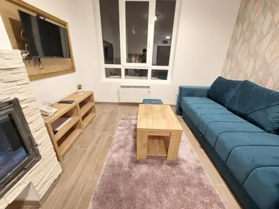 a living room with a blue couch and a coffee table at KATARINA - Lux two bedroom apartment in ski resort Kopaonik in Kopaonik