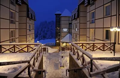 a snow covered walkway between two buildings at night at KATARINA - Lux two bedroom apartment in ski resort Kopaonik in Kopaonik