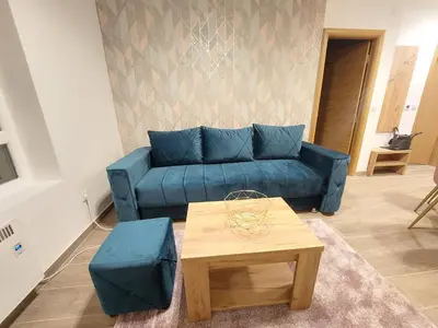 a living room with a blue couch and a table at KATARINA - Lux two bedroom apartment in ski resort Kopaonik in Kopaonik