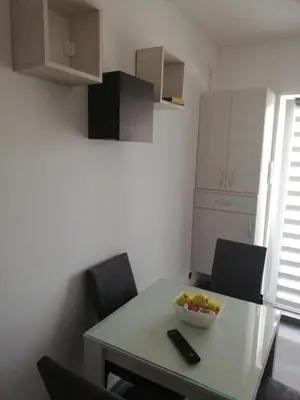 a kitchen with a table with a bowl of fruit on it at Apartman Iris in Vrnjačka Banja