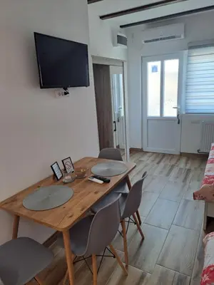 a dining room with a wooden table and chairs at NiTex Studio in Soko Banja