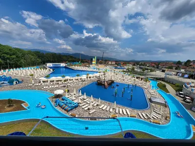 an overhead view of a large swimming pool with umbrellas and chairs at Apartman Minja in Vrnjačka Banja