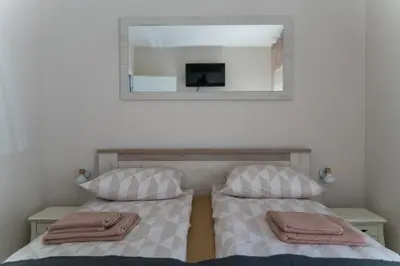 a bedroom with two beds and a mirror at JEDRO - Apartman sa garažnim parkingom in Vrnjačka Banja