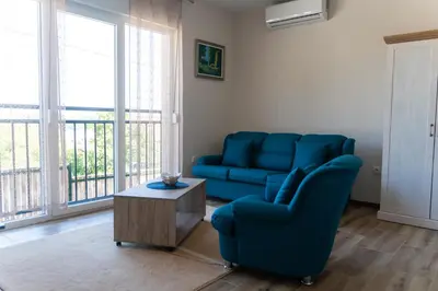 a living room with a blue couch and a table at JEDRO - Apartman sa garažnim parkingom in Vrnjačka Banja