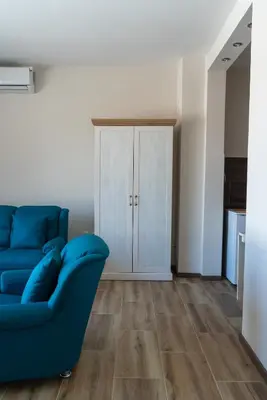 a living room with a blue couch and a cabinet at JEDRO - Apartman sa garažnim parkingom in Vrnjačka Banja