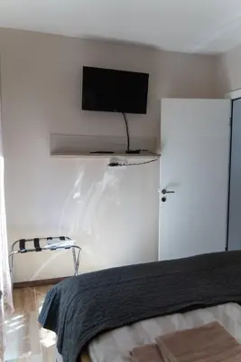 a bedroom with a bed and a tv on a wall at JEDRO - Apartman sa garažnim parkingom in Vrnjačka Banja