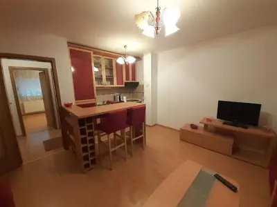 a living room with a kitchen with a bar and a tv at Nole 2 in Despotovac
