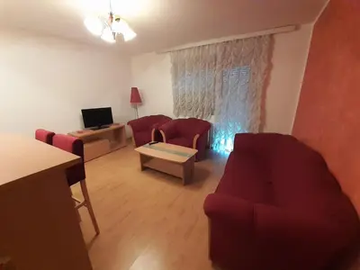 a living room with two red couches and a television at Nole 2 in Despotovac