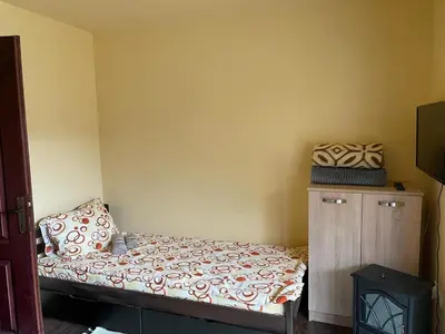 a small bedroom with a bed and a wooden cabinet at MIN apartman Goc in Vrnjačka Banja