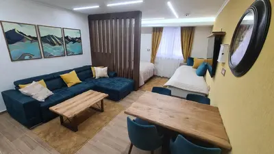 a living room with a couch and a table at Hotel Sunčana planina - Wellness & Spa - Kopaonik - Sunny Mountain Apartments in Kopaonik