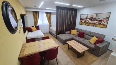a small living room with a couch and a table at Hotel Sunčana planina - Wellness & Spa - Kopaonik - Sunny Mountain Apartments in Kopaonik