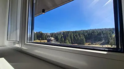 an open window with a view of a forest at Hotel Sunčana planina - Wellness & Spa - Kopaonik - Sunny Mountain Apartments in Kopaonik