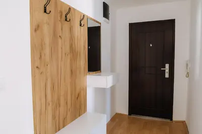 a bathroom with a wooden door and a mirror at Constantin Inn in Niš