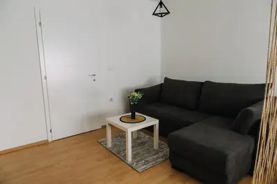 a living room with a black couch and a table at Constantin Inn in Niš
