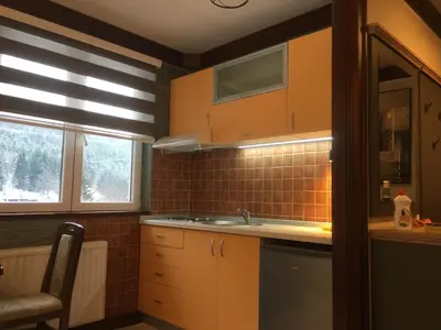 a kitchen with orange cabinets and a sink at Lux Apartman Holiday-Brzeće, Kopaonik in Brzeće