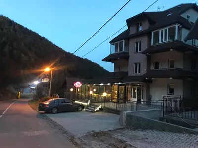 a car parked in a parking lot in front of a building at Lux Apartman Holiday-Brzeće, Kopaonik in Brzeće