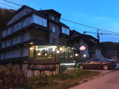 a building with a car parked in front of it at Lux Apartman Holiday-Brzeće, Kopaonik in Brzeće