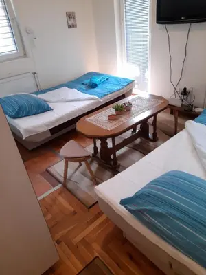 a room with two beds and a table in it at N&N in Brzeće