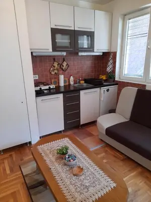 a kitchen and living room with a couch and a table at N&N in Brzeće
