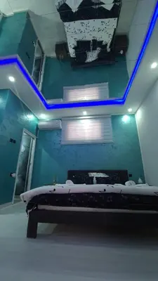 a room with a bed with blue lights on the ceiling at Apartman Melody in Paraćin