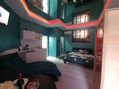 a bedroom with a bed in a room with neon lights at Apartman Melody in Paraćin