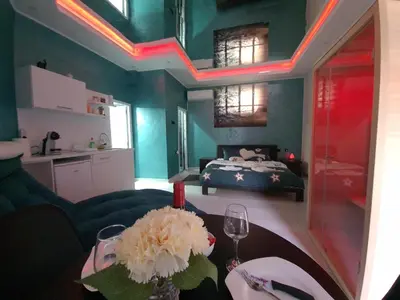 a living room with a bed and a table with flowers at Apartman Melody in Paraćin