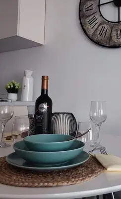 a table with a plate and a bottle of wine at Apartman MAJA in Vrnjačka Banja