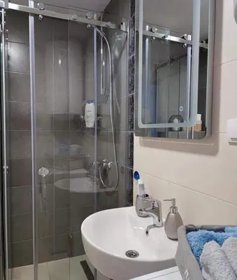 a bathroom with a sink and a glass shower at Apartman MAJA in Vrnjačka Banja