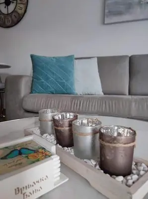 a living room with a coffee table with containers and a couch at Apartman MAJA in Vrnjačka Banja