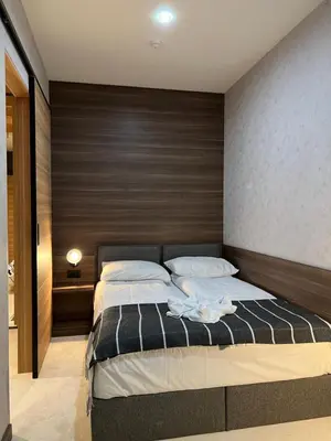 a bedroom with a large bed with a wooden headboard at Select Woodside Residence & Spa in Kopaonik