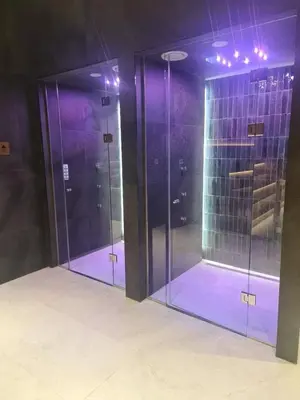 three glass doors in a room with purple lighting at Select Woodside Residence & Spa in Kopaonik
