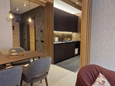 a kitchen and dining room with a table and chairs at Select Woodside Residence & Spa in Kopaonik