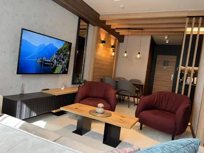 a living room with a tv on the wall at Select Woodside Residence & Spa in Kopaonik