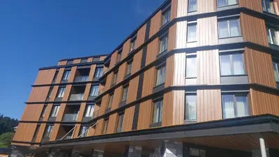 a tall building with a wooden facade at Select Woodside Residence & Spa in Kopaonik