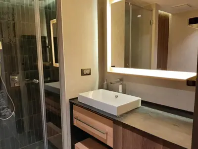 a bathroom with a white sink and a shower at Select Woodside Residence & Spa in Kopaonik