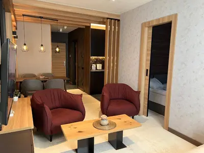 a living room with two chairs and a table at Select Woodside Residence & Spa in Kopaonik
