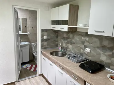 a small kitchen with a sink and a toilet at Apartmani Stanković Sokobanja in Soko Banja