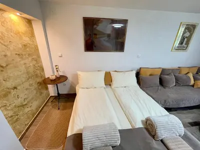 a living room with two beds and a couch at Apartmani Stanković Sokobanja in Soko Banja