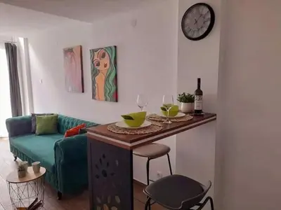 a living room with a table and a couch at Limone apartmani Niš in Niš
