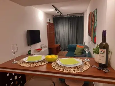 a table with two plates and a bottle of wine at Limone apartmani Niš in Niš