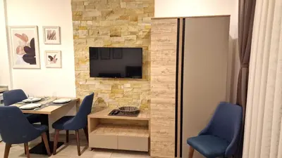 a dining room with a table and a tv on a wall at Kopaonik Bliss in Kopaonik