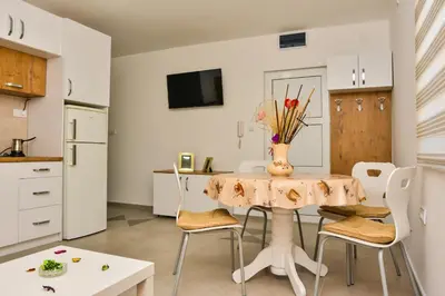 a kitchen with a table with a vase of flowers on it at Apartmani Milenkovic in Soko Banja