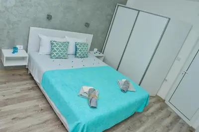 a bedroom with a bed with shoes on it at Apartmani Milenkovic in Soko Banja