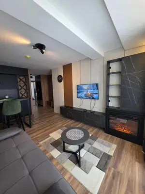 a living room with a couch and a fireplace at SkyKop Apartmani in Kopaonik